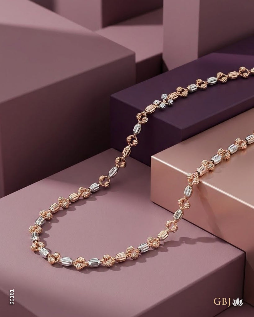 A luxury rose gold and silver beaded necklace displayed on geometric purple and pink blocks.