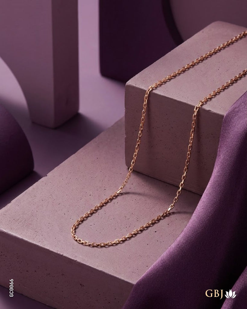 A delicate rose gold chain necklace draped elegantly across a textured concrete block and purple draped fabric, set against a minimalist purple geometric background.